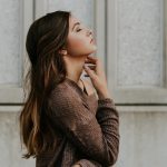 人_あごに手を当て、目をつぶって考える女性