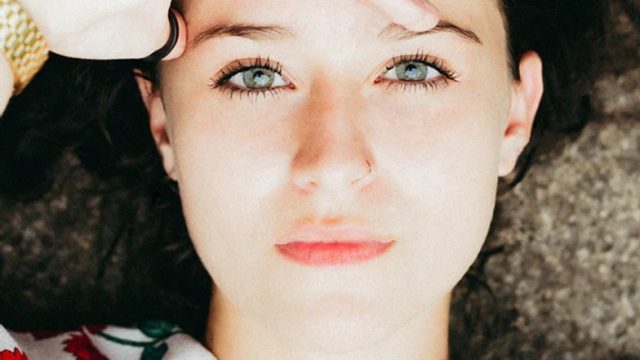 人_おでこに手を当て、よく見ようを目を凝らす女性