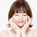 顔の横に両手を添えた目をつぶった女性の画像