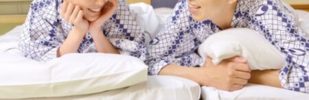 浴衣姿でうつぶせになり、敷布団の上で話をしている男女