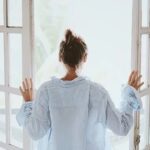 睡眠＿カーテンを開けて換気する女性
