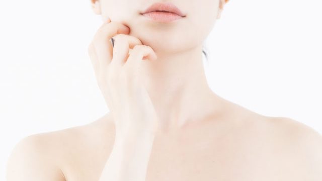 頬に手を当ててコ斜め上を見るく女性