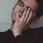 人_痛みで顔をしかめる男性