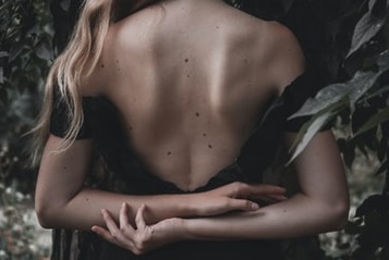 ほくろのある背中をこちらに向ける女性の画像