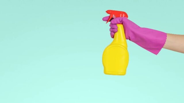 ゴム手袋をした手でもったスプレーボトル