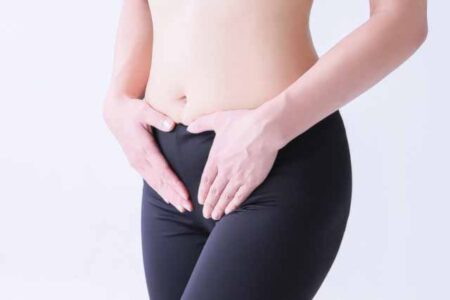 人_お腹を押さえる女性の画像