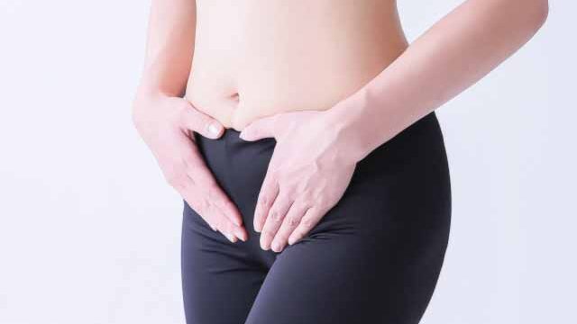 人_お腹を押さえる女性の画像
