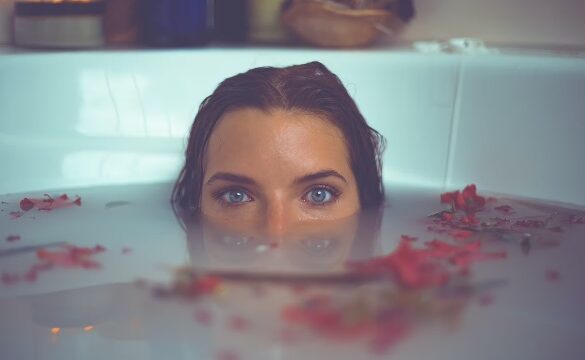 人_お風呂に鼻まで沈めてこちらを見つめる女性の画像
