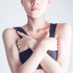 両脇を手のひらで隠す女性の画像