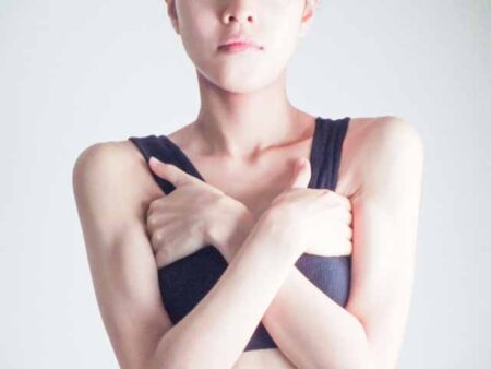 両脇を手のひらで隠す女性の画像
