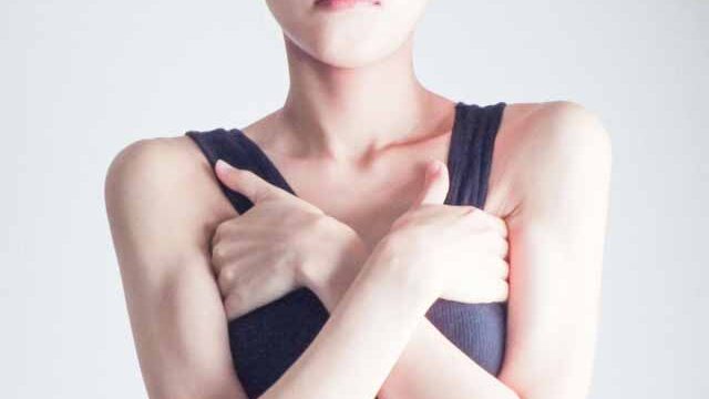 両脇を手のひらで隠す女性の画像