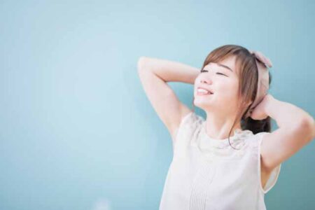 肘を上げて脇が見える女性の笑顔の女性の画像
