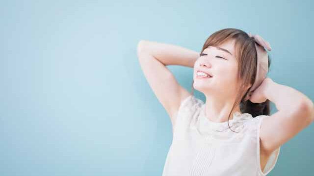 肘を上げて脇が見える女性の笑顔の女性の画像