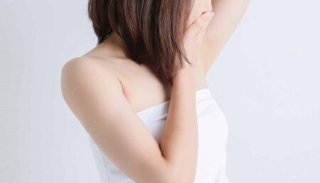 人_脇を見て口元を押さえる女性の画像1