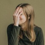人＿恥ずかしそうに手で顔を覆う女性の画像