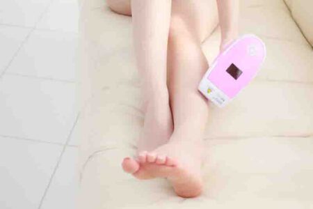 人＿脱毛器を使って足脱毛をしている女性