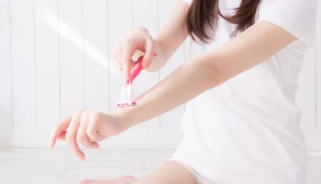 人＿腕にカミソリを当てる女性