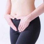 人_お腹を押さえる女性の画像